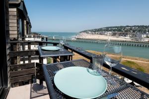 Mini-duplex cosy avec magnifique vue mer في دوفيل: طاولة مع كأسين من النبيذ وإطلالة على الشاطئ