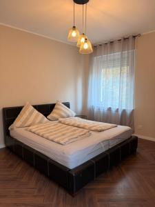 a large bed in a bedroom with a window at LevelUp 5von5 in Koblenz