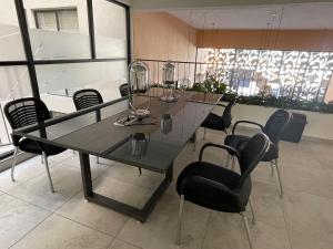 una sala de conferencias con mesa de cristal y sillas en Apartment near Zona Real Zapopan, en Guadalajara