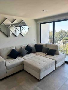 Una sala de estar con un sofá y una ventana grande. en Apartment near Zona Real Zapopan, en Guadalajara