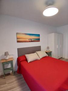 ein Schlafzimmer mit einem roten Bett mit zwei Kissen in der Unterkunft Casa Remo - Motril in Motril