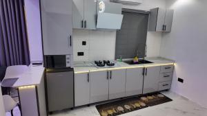 a white kitchen with a stove and a sink at White Orchid Inn in Ibadan +18 photos