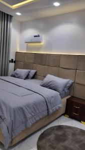 a bedroom with a large bed with a large headboard at White Orchid Inn in Ibadan