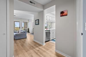 a kitchen and living room with white walls and wood floors at 1807 Heron Pt in Seabrook Island