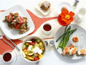 a white table with plates of food and cups of coffee at Caribbean DELUXE VILLAS Los CORALES beach, POOL & SPA in Punta Cana