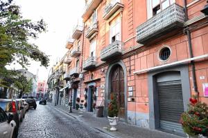 a cobblestone street with buildings and cars parked at Le Due Muse b&b in Pagani