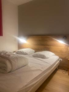 Les toits de dévoluy في لو ديفولي: غرفة نوم بها سريرين مع ملاءات ووسائد بيضاء +22 صورة