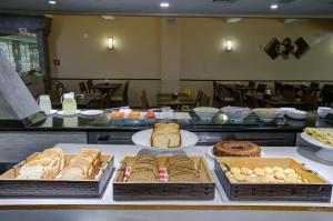 Una línea de buffet con diferentes tipos de pan y pasteles. en Transamerica Executive Perdizes, en São Paulo