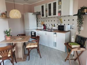 a kitchen with white cabinets and a table and chairs at Pogled Ada 1 in Belgrade