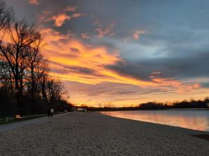 a person walking on the shore of a lake at sunset at Pogled Ada 1 in Belgrade