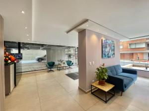 a living room with a blue couch and a table at EspacioYa By Mario Rental Calle 100 in Bogotá
