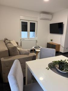 een woonkamer met een bank, een tafel en stoelen bij Apartman Rest Novi Sad in Novi Sad +5 foto's