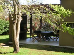 a patio with a table and chairs in a yard at Complejo Aires del Bosque in Chascomús