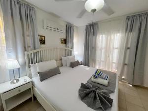 a bedroom with a large white bed with a pillow on it at Caribbean DELUXE VILLAS Los CORALES beach, POOL & SPA in Punta Cana