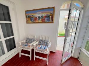 a room with two chairs and a painting on the wall at Caribbean DELUXE VILLAS Los CORALES beach, POOL & SPA in Punta Cana +28 photos