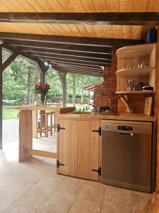 een keuken met houten kasten en een vaatwasser bij Misha's House in Porumbacu de Sus