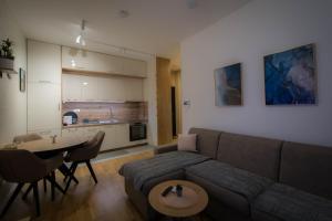 een woonkamer met een bank en een tafel bij Pro-Link Podgorica in Podgorica