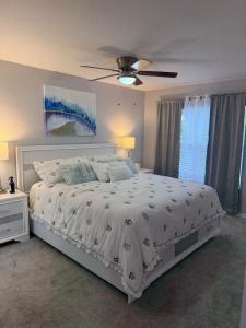 a bedroom with a white bed with a ceiling fan at Luxury house in Disney in Kissimmee +29 photos