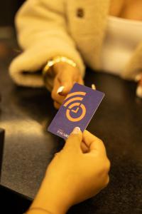 a person holding up a purple card with a symbol at Hotel Continental ByHours in Bogotá