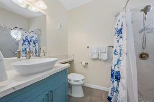 a white bathroom with a sink and a toilet at Marbella Lane - Sunshine Seascape Ocean View in Malae