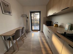 een keuken met een aanrecht, een tafel en stoelen bij Apartaments Rocha 159 - Blisko Jasnej Góry in Częstochowa +15 foto's