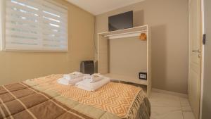 a bedroom with a bed with two towels on it at Departamentos Turísticos MD in El Calafate