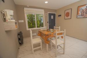 a dining room with a table and chairs and a window at Departamentos Turísticos MD in El Calafate