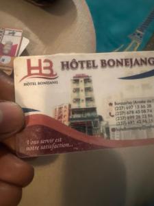 eine Person, die eine Eintrittskarte für ein Hotelgebäude besitzt in der Unterkunft Hôtel Bonejang in Douala