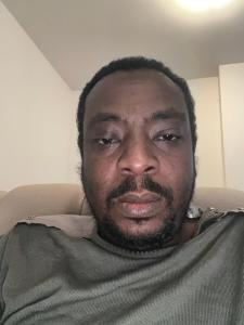 ein Mann mit Bart sitzt auf einem Stuhl in der Unterkunft Hôtel Bonejang in Douala