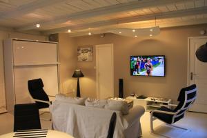 a living room with a couch and a tv on the wall at Escalille le Royale in Lille