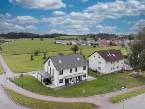 an aerial view of a house with a green field at HEIMATEL - Ferienhaus im Alpenblick in Primisweiler