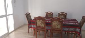 a dining room table with six chairs and a table cloth at dar fatma matmata in Matmata