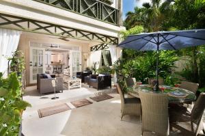 eine Terrasse mit Tisch und Sonnenschirm in der Unterkunft Beacon Hill 202 - Moonshadow by Blue Sky Luxury in Saint Peter