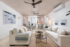 ein Wohnzimmer mit weißen Möbeln und einem Deckenventilator in der Unterkunft Beacon Hill 202 - Moonshadow by Blue Sky Luxury in Saint Peter