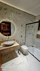 a bathroom with a sink and a toilet and a shower at Casa Amaral in Capitólio +16 photos