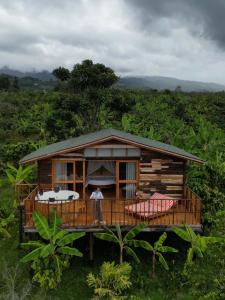 a man standing in front of a wooden house at LA PERLA FINCA HOTEL in Gigante