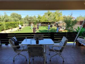 a table and chairs on a patio with a soccer field at George's family friendly maisonette with great exterior in Drosia