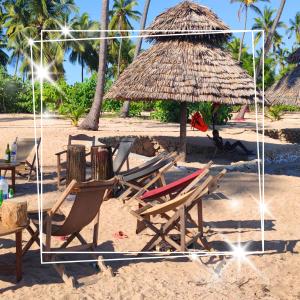 AFLII Beach Resorts Msangamkuu في متوارا: مجموعة من الكراسي ومظلة القش على الشاطئ +4 صور