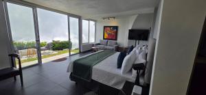 una camera da letto con un letto grande e una grande finestra di Hotel Finca Campo Bello a Cerro Verde Altre 56 foto