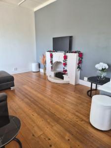 a living room with a fireplace and a tv at Holland Manor in Durban