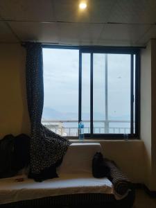 Habitación con ventana grande y sofá en la parte delantera. en All khair guest house Murree, en Murree