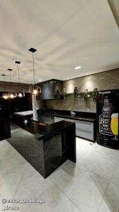 a kitchen with a black counter and potted plants at Casa Amaral in Capitólio
