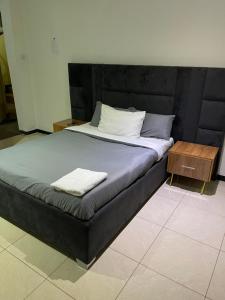 un letto con testiera nera e tavolo in legno di Henderson street lodge a Blantyre