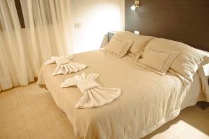 a white bed with white towels on top of it at Puerto Mineral Hotel & Golf in Capioví +145 photos