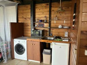 a kitchen with a washing machine and a washer at Bungalow studio in Raiatea
