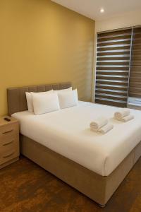 een slaapkamer met een groot bed met twee handdoeken erop bij The Miles Arms Hotel in Avonmouth