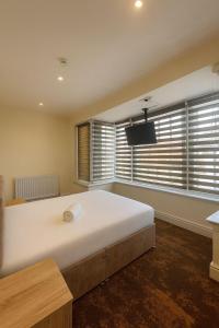 een groot bed in een kamer met een groot raam bij The Miles Arms Hotel in Avonmouth