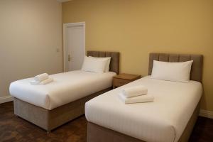 twee bedden naast elkaar in een kamer bij The Miles Arms Hotel in Avonmouth