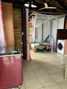 a room with a bed and a washing machine at Bungalow studio in Raiatea