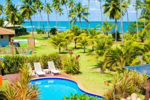 a resort with a pool and palm trees and the ocean at Casa Edy Casa Vacanze vista mare con piscina a 200 m dalla spiaggia - Perfetta per famiglie e gruppi in Praia do Forte